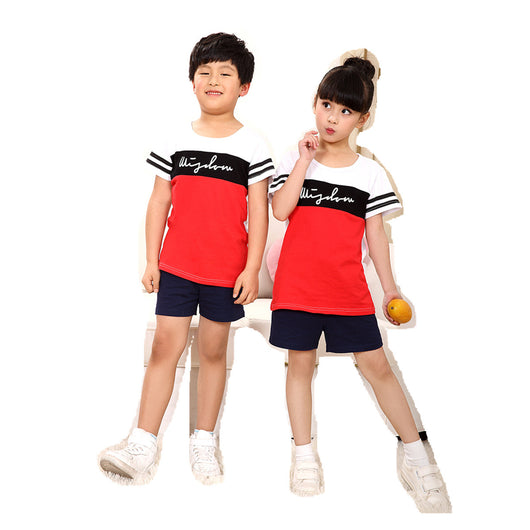 Family of four wearing matching black, white, and red color block t-shirts with navy shorts, posing happily. - Image 12