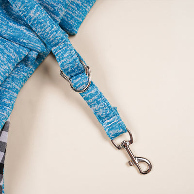 Person in white hoodie carrying a happy white dog in a navy blue pet sling bag outdoors. - Image 39