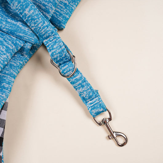 Person in white hoodie carrying a happy white dog in a navy blue pet sling bag outdoors. - Image 39
