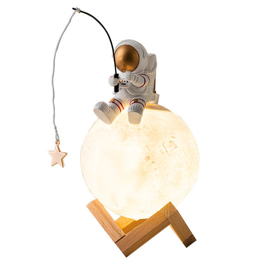 Astronaut figurine sitting on a glowing moon lamp, holding a fishing rod with a star charm, on a wooden stand. - Image 3