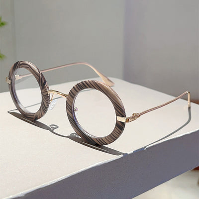 Small frame oval fashion sunglasses with black frames and vibrant orange lenses, held by a hand. - Image 27