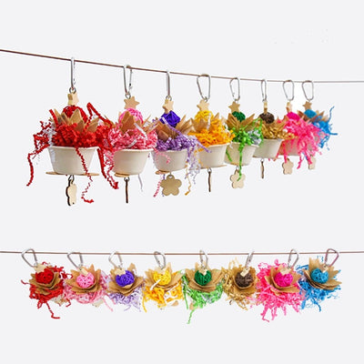 Blue parrot flower clump bite toy with shredded paper, wooden pieces, and a hanging metal clip.