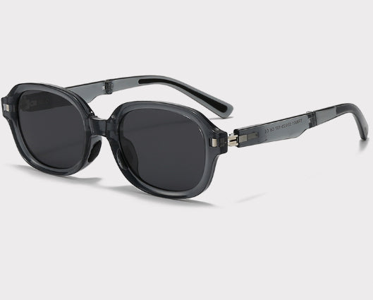 Brown oval sunglasses with dark lenses and thick frames, featuring visible silver hinges on a light gray background. - Image 17