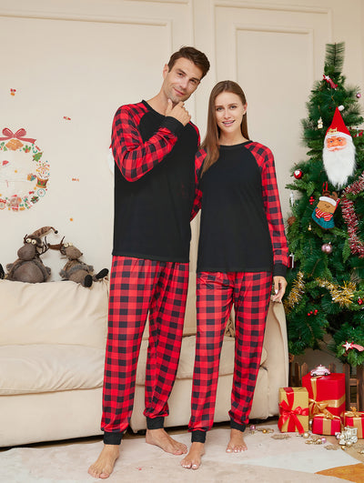 Family of four wearing matching black and red buffalo plaid pajamas in a festive Christmas living room. - Image 3