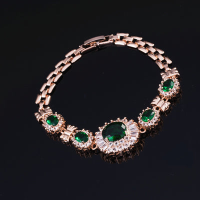Rose gold tone jewelry set with oval blue gemstones and clear accents, including a necklace, bracelet, earrings, and ring. - Image 7