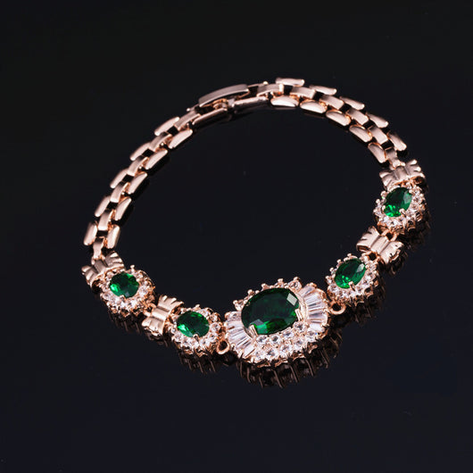 Rose gold tone jewelry set with oval blue gemstones and clear accents, including a necklace, bracelet, earrings, and ring. - Image 7