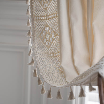 Close-up of a beige semi-transparent curtain with a delicate crochet lace trim and decorative tassels. - Image 21