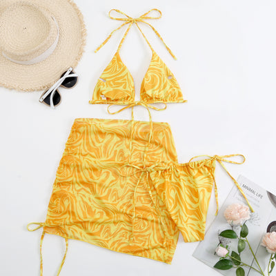 Women's three-piece swimsuit in red and orange abstract swirl print, featuring a halter bikini top, tie-side bottoms, and a ruched mini skirt. - Image 6