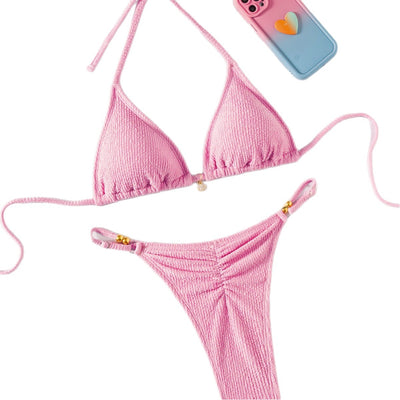 Pink textured halter bikini swimsuit with gold beads and a shell charm, worn by a woman on a wooden surface. - Image 5