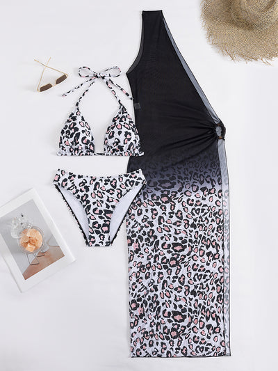 Woman in a three-piece leopard print bikini and sheer black sarong cover-up on a sunny beach. - Image 17