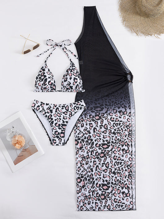 Woman in a three-piece leopard print bikini and sheer black sarong cover-up on a sunny beach. - Image 17