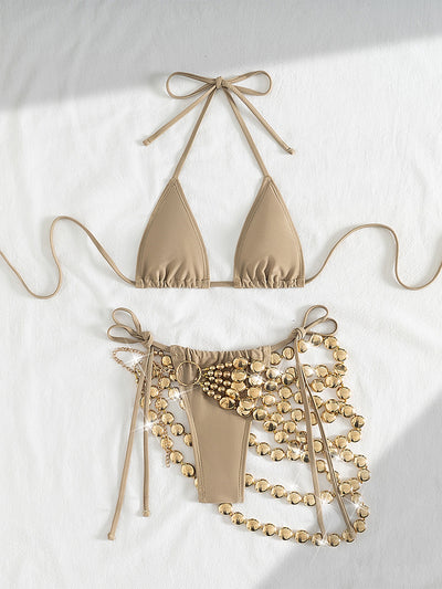 Copper halter bikini top and bottom with a gold beaded skirt, laid flat with sunglasses, seashell, and flowers. - Image 9