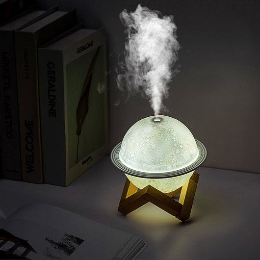 White moon-shaped humidifier with a textured surface resembling craters and a thin ring around its middle. - Image 4