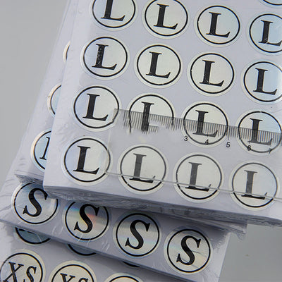 Stack of round clothing size stickers with laser color-changing background and black text, from XS to 4XL. - Image 18