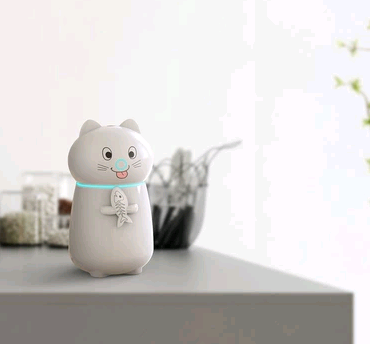 White cartoon cat humidifier with a pink tongue, black eyes, and whiskers, holding a fish skeleton, with a glowing blue light band. - Image 2