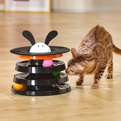Brown tabby cat sniffing a black and orange multi-level rotating cat plate toy with colorful balls and bunny ears. - Image 8