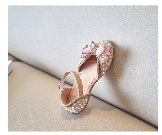 Beige girls' shallow mouth pumps with a large pink pearl bow, glitter, and an ankle strap with a gold buckle. - Image 19