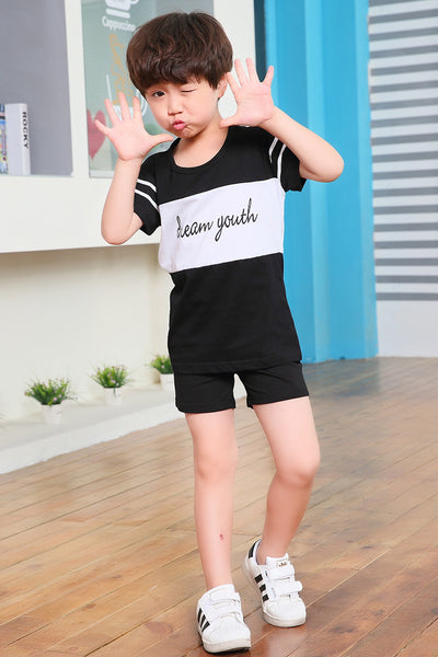 Young girl in a white short-sleeve t-shirt with a black stripe and black shorts, wearing a black cap. - Image 25