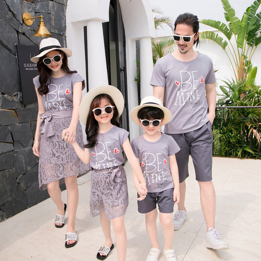 Family of four in matching grey "BE MINE" outfits. Mother and daughter wear lace skirts, father and son wear shorts. - Image 4