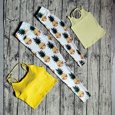 White parent-child yoga suit with tropical leaf print leggings and matching sleeveless tops.