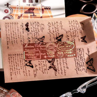 Retro laser washi tape with holographic postal stamps, airmail markings, and travel-themed text on a brown background. - Image 8