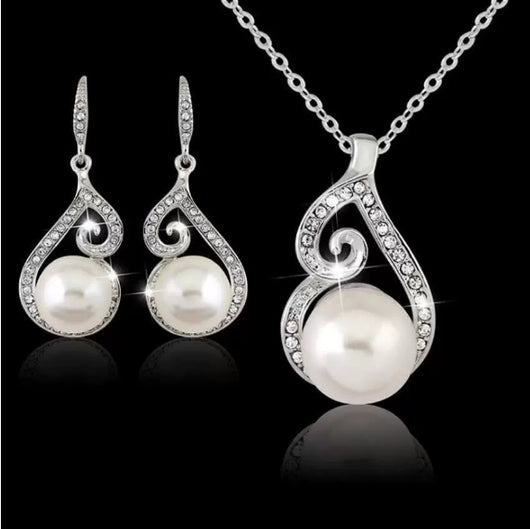 Silver-tone rhinestone and faux pearl drop necklace and matching earrings jewelry set on a black background. - Image 6
