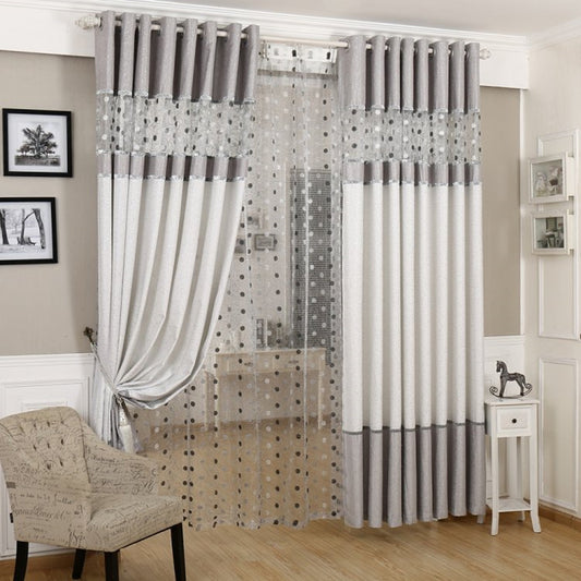 Grey and white two-tone blackout curtains with a sheer polka dot panel, hung on a white grommet rod.