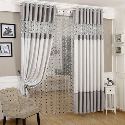 Grey and white two-tone blackout curtains with a sheer polka dot panel, hung on a white grommet rod.