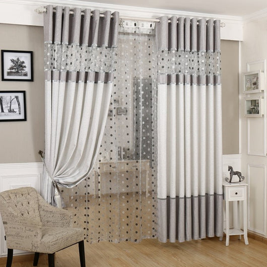 Grey and white two-tone blackout curtains with a sheer polka dot panel, hung on a white grommet rod.