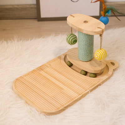 White cat playing with a wooden multi-level track toy featuring a spring-mounted yellow feather ball and a green catnip ball. - Image 15