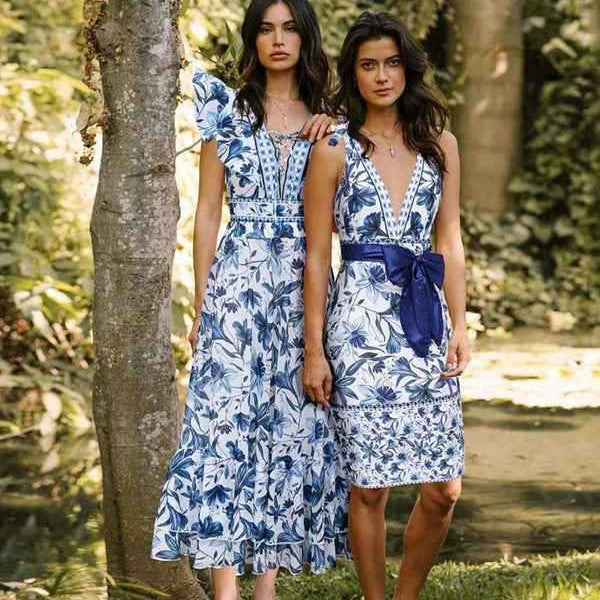 Women's blue and white floral one-piece swimsuit with ruffled V-neck and matching sarong skirt with bow.