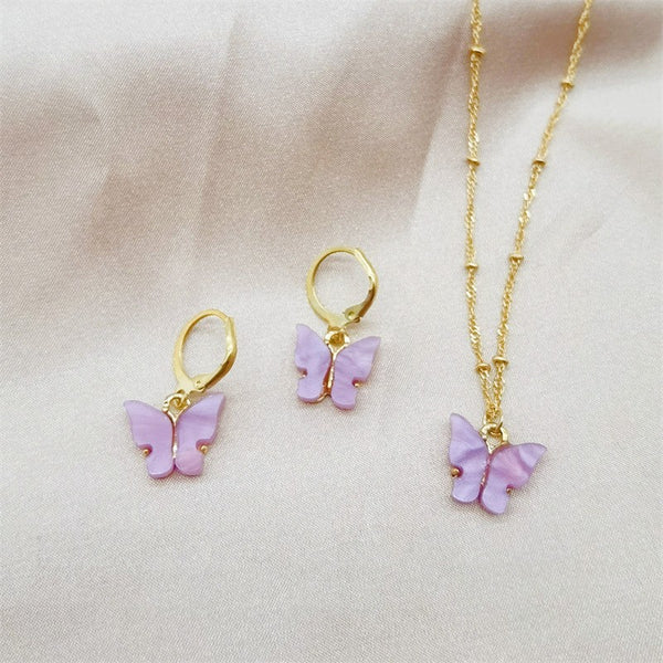 Pink acrylic butterfly necklace and earring set with gold-colored chain and hoop earrings.