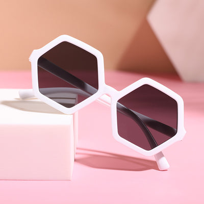 Red hexagonal children's sunglasses with dark lenses on a pink surface with a white block. - Image 7