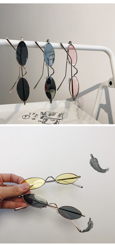 Silver-framed oval sunglasses with dark lenses reflecting a warm-toned object, displayed on a white tray. - Image 11
