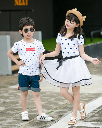Family of four wearing matching white and black polka dot outfits. Dad and son in t-shirts, mom and daughter in dresses. - Image 8
