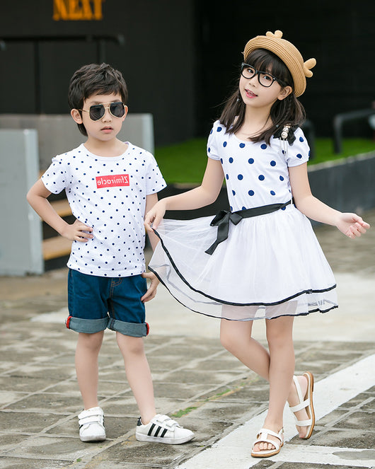 Family of four wearing matching white and black polka dot outfits. Dad and son in t-shirts, mom and daughter in dresses. - Image 8