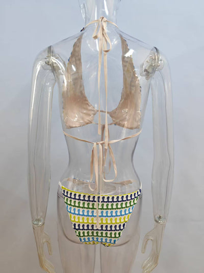 Woman in a blue, green, and yellow patterned halter bikini top and matching flowy sarong on a sunny beach. - Image 14