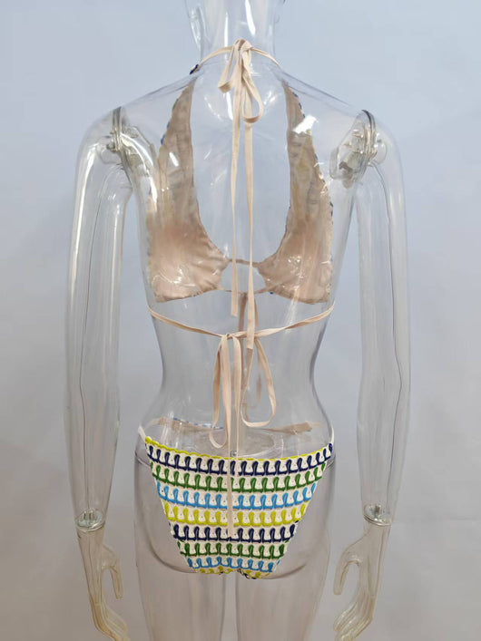 Woman in a blue, green, and yellow patterned halter bikini top and matching flowy sarong on a sunny beach. - Image 14