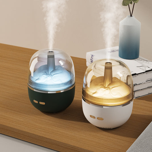 White essential oil diffuser and humidifier with a clear dome top, glowing red inside, and blue LED base light.