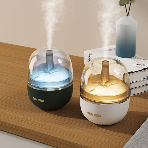 White essential oil diffuser and humidifier with a clear dome top, glowing red inside, and blue LED base light.