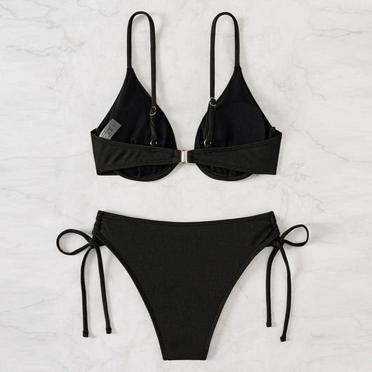 Black ribbed two-piece bikini with an underwire top and tie-side bottoms on a white marble surface. - Image 4
