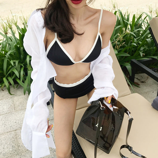 Woman in a black and white triangle bikini with high-waisted bottoms, relaxing on a beach chair. - Image 3