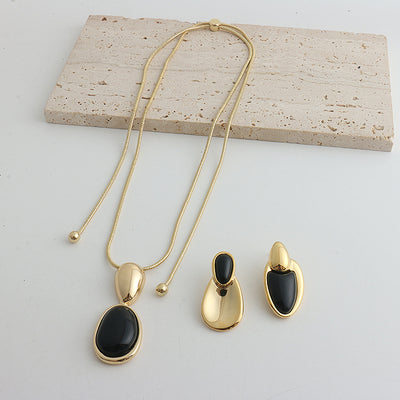 Pair of gold-toned irregular earrings with black onyx-like inserts, featuring a modern, abstract design. - Image 15
