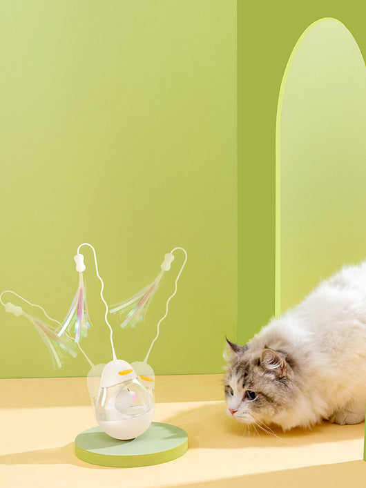 Yellow duck egg shaped tumbler cat toy with a clear middle, containing a yellow ball, and a flexible wand with purple and pink streamers. - Image 11