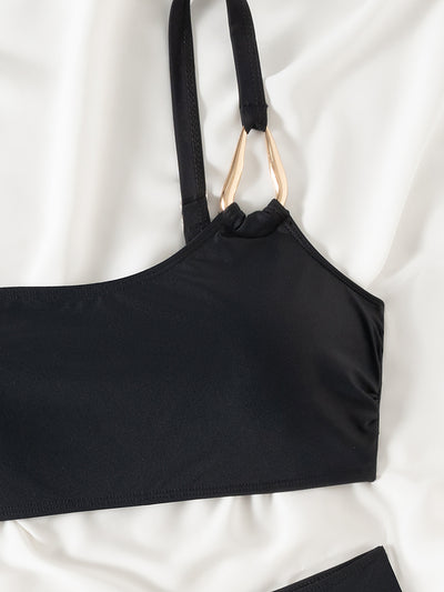 Black one-shoulder bikini with a gold-tone metal buckle detail and high-waisted bottoms with a V-front design. - Image 16