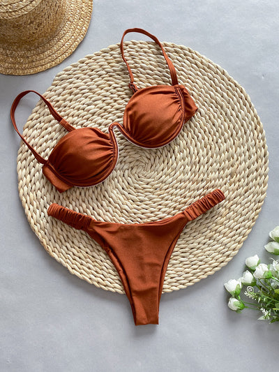 Rust underwire bikini set with ruched top and high-cut bottom, displayed on a woven mat. - Image 6