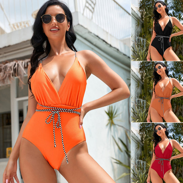 Red one-piece swimsuit with a deep V-neckline and a black and white striped rope belt, modeled outdoors.
