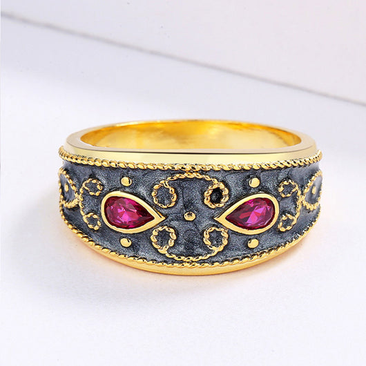 Gold-toned wide band ring with dark gray enamel, intricate scrollwork, and two fuchsia teardrop gemstones. - Image 3