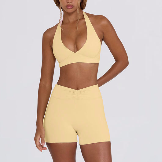 Light pink halter neck sports bra and high-waisted leggings workout set on a model. - Image 25