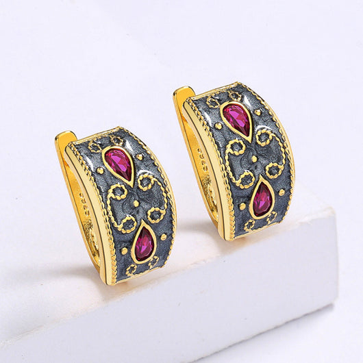 Gold-toned wide band ring with dark gray enamel, intricate scrollwork, and two fuchsia teardrop gemstones. - Image 5